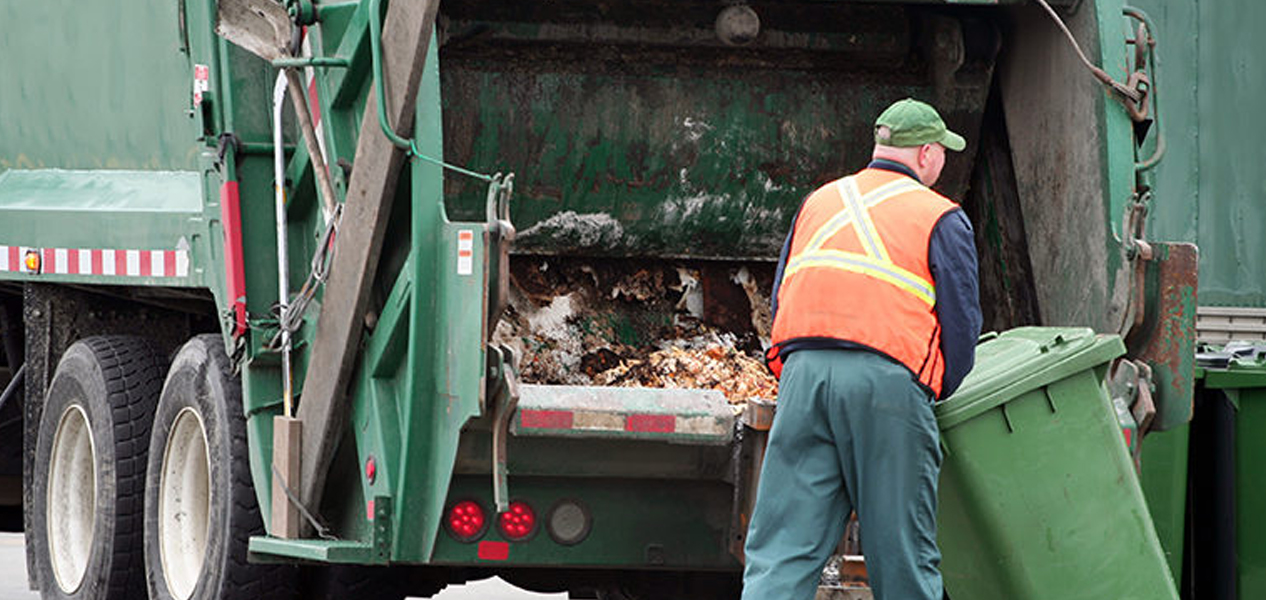 Junk hauling truck collecting items near a residential property