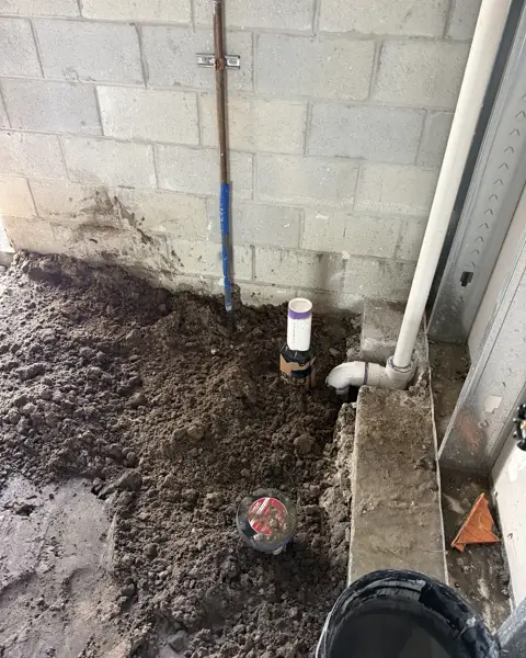 Cleanout set into the fill at a block wall