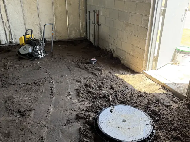 Trench backfilled and compacted around the finished cleanout cover